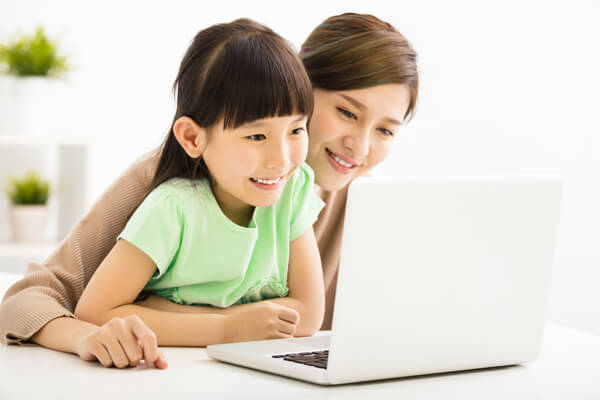 A child learning with her mother beside her.